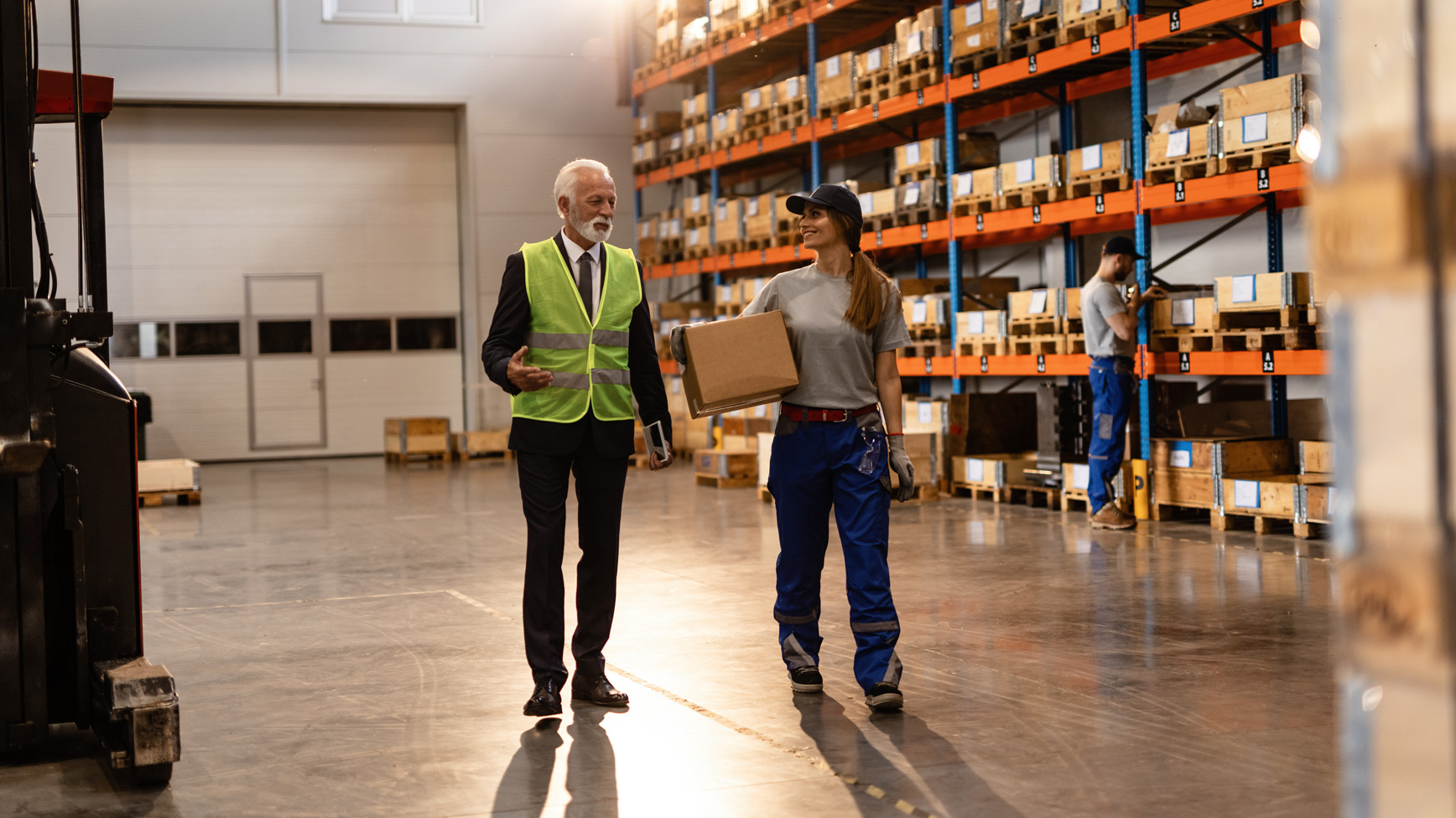 News update banner featuring a warehouse employee in blue coveralls and a supervisor with a safety vest conversing on the warehouse floor, with shelves of boxed inventory in the background. Celebrating 36 years.